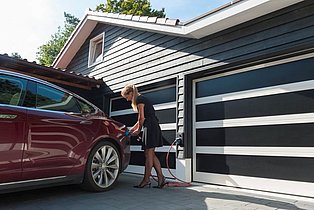 Schwarze Garage mit Elektroladesäule