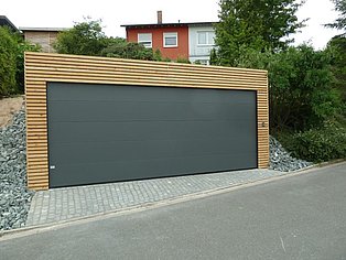 Holzgarage mit dunkelgrauem Tor