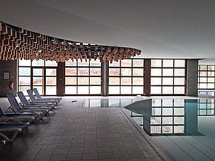 Indoor-Pool mit Deckenskulptur und Liegen